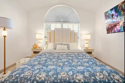 a bedroom with a large bed with a blue and white blanket at Luxury Villa, Welcome to EDC, Pool & Spa in Orlando