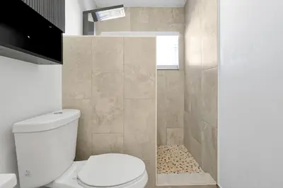 a white bathroom with a toilet and a shower at Luxury Villa, Welcome to EDC, Pool & Spa in Orlando