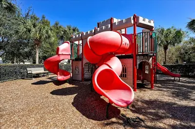 a playground with a red slide in a park at Disney Dream in Orlando
