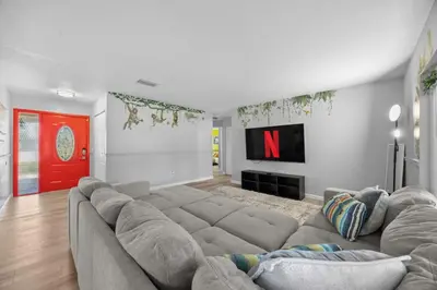 a living room with a large couch and a red door at Red Jordan Boho Style Vacation Home in Orlando