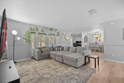 a living room with a couch and a table at Red Jordan Boho Style Vacation Home in Orlando