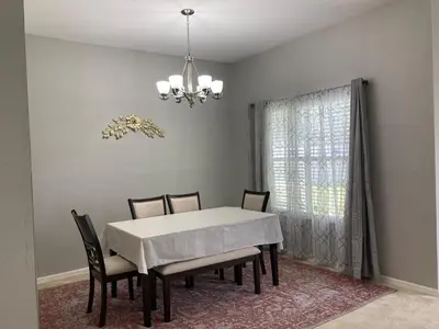 a dining room with a white table and chairs at Orlando HomeDisney and beach in Orlando