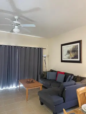 a living room with a couch and a table at Spacious 4 BR Townhouse with 2 King Size Master Bedrooms, 3 miles to Disney, Free WiFi and Free Parking in Orlando
