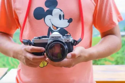 a person holding a camera with a mickey mouse on it at Secret Resort Kissimmee Lakeview Condo in Kissimmee