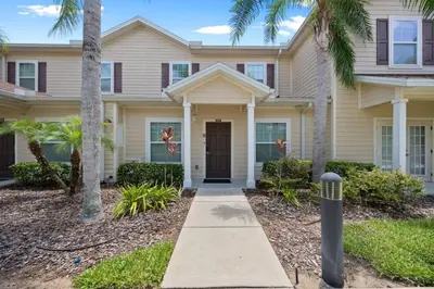 a house with palm trees in front of it at Magical Disney Getaway- Belle Potter & Minions in Kissimmee