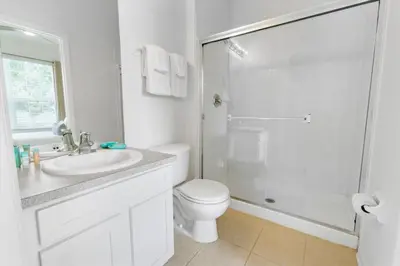 a white bathroom with a toilet and a shower at Windsor Hills Family-Friendly 3BR Pool Townhome in Orlando
