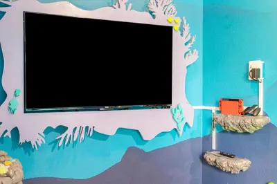 a flat screen tv on a wall with a painting of a beach at Windsor Hills Family-Friendly 3BR Pool Townhome in Orlando