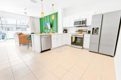 a kitchen with white appliances and a couch at Windsor Hills Family-Friendly 3BR Pool Townhome in Orlando