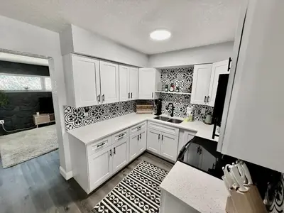 a kitchen with white cabinets and a black and white rug at Relaxing 3BR Home Near Orlando Downtown & Parks in Orlando