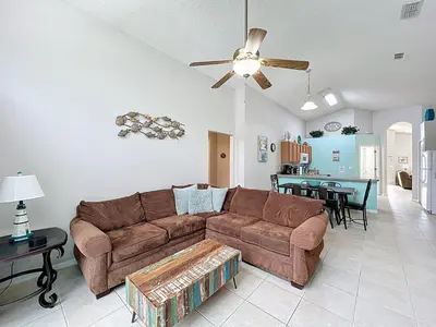 a living room with a couch and a dining room at Family Fun Tropical Home in Kissimmee