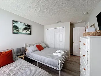 a bedroom with a bed and a dresser at Family Fun Tropical Home in Kissimmee