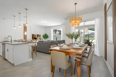 a kitchen and dining room with a wooden table and chairs at Casa 4Q Storey Lake c/ Piscina e Quartos Disney in Kissimmee