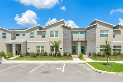 a large apartment building with a parking lot at Casa 4Q Storey Lake c/ Piscina e Quartos Disney in Kissimmee