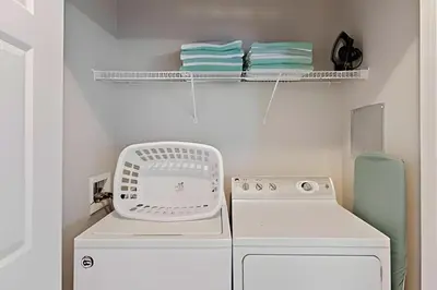 a laundry room with a washing machine and shelves at Apartamento 3Q Vista Cay Perto dos Parques in Orlando