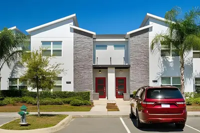 a red car parked in front of a house at Casa 4Q Disney c/ Piscina e Quartos Temáticos in Kissimmee
