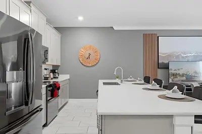 a kitchen with a white counter and a refrigerator at Casa 4Q Disney c/ Piscina e Quartos Temáticos in Kissimmee