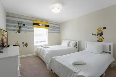 a bedroom with two beds and a tv in it at Charmosa Casa 4Q c/ Piscina - Perto da Disney in Kissimmee