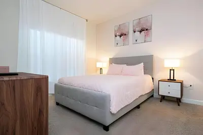 a bedroom with a white bed and two lamps at Casa 4Q c/ Piscina e Temas Mickey & Harry Potter in Kissimmee