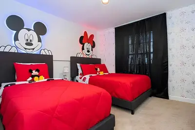 a bedroom with two beds with red sheets and a mickey mouse mural at Casa 4Q c/ Piscina e Temas Mickey & Harry Potter in Kissimmee