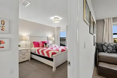 a white bedroom with a bed and a window at Villa 6Q Storey Lake c/ Piscina, Spa e EV Charger in Kissimmee