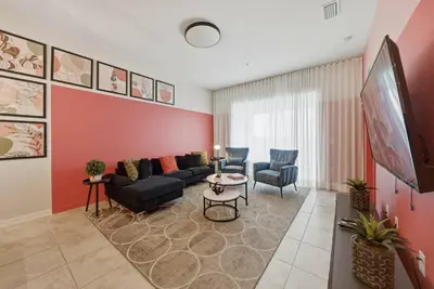 a living room with a couch and a tv at Cozy 2 Bedrooms At Storey Lake in Kissimmee