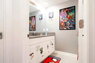 a bathroom with white cabinets and a sink at Casa 4Q c/ Piscina e Quartos Temáticos in Kissimmee