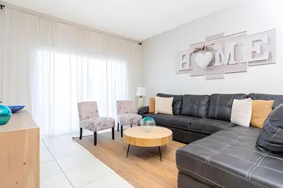 a living room with a black leather couch and chairs at Casa 4Q Disney c/ Piscina e Quartos Temáticos in Kissimmee