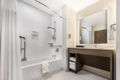 a bathroom with a tub and a sink and a shower at Comfort Inn & Suites Orlando Sanford Airport in Sanford