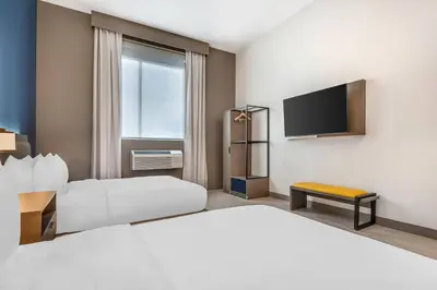 a hotel room with two beds and a flat screen tv at Comfort Inn & Suites Orlando Sanford Airport in Sanford