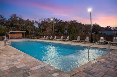 a swimming pool with lounge chairs in a resort at Comfort Inn & Suites Orlando Sanford Airport in Sanford