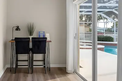 a dining room with a table and chairs and a pool at Casa 4Q c/ Piscina e Game Room – Perto Disney in Orlando