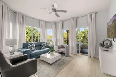 a living room with a blue couch and a ceiling fan at Sleek & Stylish Stay Mins to Magic MP68 in Orlando