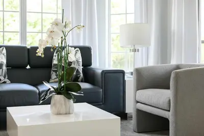 a living room with a couch and a table with flowers at Sleek & Stylish Stay Mins to Magic MP68 in Orlando