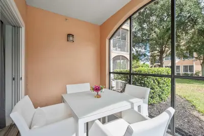 a dining room with a white table and white chairs at Serene Disney Getaway Designer Style MP61 in Orlando