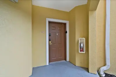 an empty hallway with a door and a fire extinguisher at Serene Disney Getaway Designer Style MP61 in Orlando
