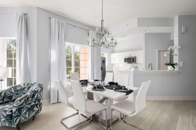 a white dining room with a white table and white chairs at Designer Retreat 2 Miles to Disney MP21 in Orlando
