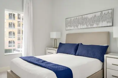 a bedroom with a large bed with blue pillows at Designer Retreat 2 Miles to Disney MP21 in Orlando