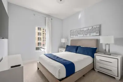 a white bedroom with a bed and a window at Designer Retreat 2 Miles to Disney MP21 in Orlando
