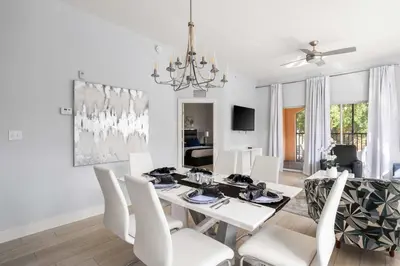 a white dining room with a table and chairs at Designer Retreat 2 Miles to Disney MP21 in Orlando