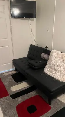 a black couch in a room with a red rug at Casita próximo Disney - mickeyfl-2 in Kissimmee