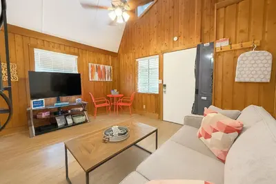 a living room with a couch and a table at Cottage-pvt Lake & Pool Access Near Disney Wporch in Clermont
