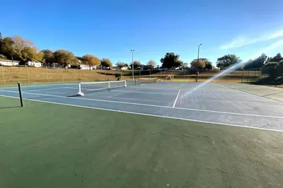 a tennis court with a sprinkler on it at Cottage-pvt Lake & Pool Access Near Disney Wporch in Clermont