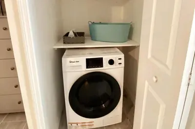 a washing machine in a corner of a room at Lilac Loft- Lake, Pool, Pickle Ball, Disney, Fun! in Clermont