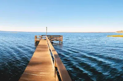 a wooden dock in the middle of the water at Lilac Loft- Lake, Pool, Pickle Ball, Disney, Fun! in Clermont