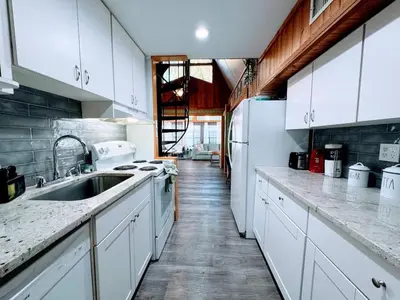 a kitchen with white cabinets and a sink at Pumba's Place - Fun, Lake, Pool- No Cleaning Fees! in Clermont