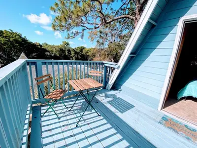 a wooden bench sitting on the deck of a house at Pumba's Place - Fun, Lake, Pool- No Cleaning Fees! in Clermont