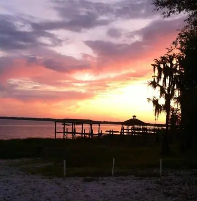 a sunset over a pier on the beach at Stay The Enchanted Escape ! in Clermont