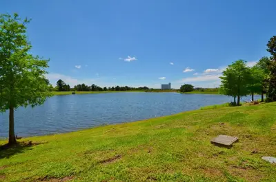 a view of a lake with a bench on the grass at Penthouse Corner at Vista Cay in Orlando