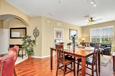 a dining room and living room with a table and chairs at Penthouse Corner at Vista Cay in Orlando