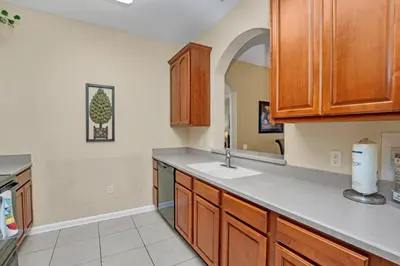 a kitchen with wooden cabinets and a sink at Vista Cay Penthouse Luxury in Orlando